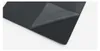 A black gaming mousepad with a corner peeled back to reveal a lighter gray underside. Produktbild-Vorschau