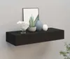 A black floating shelf mounted on a light gray wall, decorated with various objects. Voir les images du produit