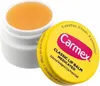 A close-up shot of an open Carmex Classic Medicated Lip Balm jar with its yellow lid resting beside it. Anteprima dell’immagine prodotto