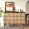 A wooden sideboard with a black top, decorated with a framed picture, a bottle of wine, a cocktail, and candles. Produktbild-Vorschau