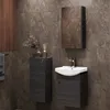 A modern bathroom vanity with a sink and storage cabinets against a tiled wall. Produktbild-Vorschau