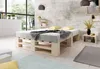 A bedroom scene featuring a pallet bed with bedding and pillows, a bedside table with a vase of flowers, and a large window overlooking greenery. Produktbild-Vorschau