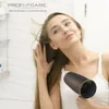 A young woman is drying her hair with a hairdryer in a bathroom. Náhled obrázku produktu