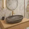 A modern bathroom vanity with a stone vessel sink and gold faucet. Produktbild-Vorschau