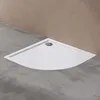 A white corner shower tray with a silver drain is placed on a concrete floor against a brown wall. Produktbild-Vorschau