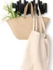 A black hook rack with two bags and flowers hanging on it. Anteprima dell’immagine prodotto