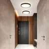 A modern hallway with a dark wooden door, textured walls, and ceiling lights. Náhľad obrázku produktu