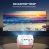A mini projector is projecting a sunset beach scene onto a large screen. The projector is white with red accents and silver details. Produktbild-Vorschau