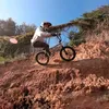 A person riding a bicycle on a dirt hill. Produktbild-Vorschau