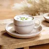 A coffee cup and saucer on a wooden surface. Produktbild-Vorschau