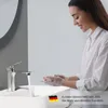 A woman washing her hands at a sink with a modern faucet. Náhled obrázku produktu