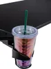 A close-up of a cup holder attached to a desk, holding a cup with a straw. Produktbild-Vorschau