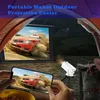 A portable projector is set up outdoors at night, projecting a movie onto a screen. A person is holding a smartphone, also displaying the movie, and a backpack is visible. Produktbild-Vorschau