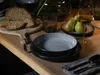 A table setting with bread, plates, pears, and wine. Náhľad obrázku produktu