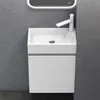 A modern white sink and vanity unit against a gray textured wall. Voir les images du produit