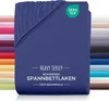 A folded navy blue fitted sheet is shown against a white background, with a stack of other colored sheets visible on the left and right sides.
