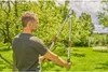A man is holding a pair of long-handled pruning shears in a garden. Produktbild-Vorschau