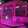 A pergola decorated with pink string lights at night. Produktbild-Vorschau
