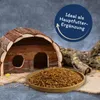 A wooden animal house, a pile of dried shrimp, and a branch are arranged on a textured surface. Produktbild-Vorschau