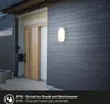 An outdoor wall lamp is mounted on a dark gray, horizontally paneled house wall, with rain falling. A wooden door is visible to the left. Produktbild-Vorschau