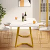 A white marble dining table with gold legs is set with drinks and bottles of wine, surrounded by white bar stools. A gold and white china cabinet is visible in the background. Produktbild-Vorschau