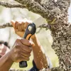 A person is using a folding saw to cut a tree branch. Produktbild-Vorschau