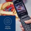 A hand holding a flip phone, with a background of fruit and a blue overlay with a camera icon and text. Náhľad obrázku produktu