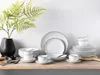 A set of white porcelain dishes with black trim, arranged on a wooden shelf. Podgląd zdjęcia produktu