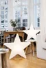 Two large star-shaped lamps are lit up in a bright, airy room with large windows and wooden furniture. Produktbild-Vorschau