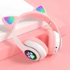 A pair of pink cat-ear headphones with LED lights, displayed on a pink surface. Náhľad obrázku produktu