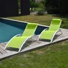 Two green sun loungers with white frames are placed on a wooden deck next to a swimming pool. Voir les images du produit