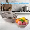 A kitchen scene with stainless steel colanders and fruit in a bowl. Produktbild-Vorschau