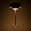 A modern table lamp with a circular base and a layered, disc-shaped shade. Produktbild-Vorschau