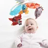 A baby looking up at a mobile with stuffed animal toys. Voir les images du produit