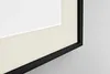 A close-up view of a framed picture with a cream-colored mat and a black frame. Produktbild-Vorschau