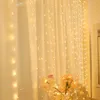 A curtain decorated with fairy lights, with a basket of flowers in the foreground. Produktbild-Vorschau