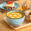 A table setting with a bowl of soup, a slice of cake, and honey. Náhled obrázku produktu