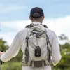 A person is hiking with a backpack that has a small black speaker attached to it. Voir les images du produit