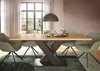 A dining table with chairs in a well-lit room with a large window. Produktbild-Vorschau