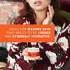 A woman is holding a small jar of face cream. Produktbild-Vorschau