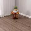 A small wooden table with books and a plant sits on a wooden floor next to a white curtain. Anteprima dell’immagine prodotto