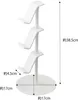 A white three-tiered stand for holding controllers or headsets, with dimensions indicated by text overlays. Produktbild-Vorschau