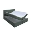 A green bed with its storage compartment open, revealing the interior and a white mattress on top. Produktbild-Vorschau