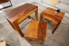 Three wooden side tables are arranged on a rug in a living room setting. One table has a cup of coffee on it. Produktbild-Vorschau