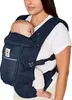 A woman is wearing a baby carrier with a baby inside. Produktbild-Vorschau