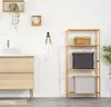 A bathroom scene with a vanity, sink, shelving unit, and a towel hanging on a hook. Anteprima dell’immagine prodotto