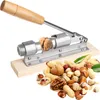 A nutcracker with a walnut being cracked, surrounded by a pile of various nuts. Voir les images du produit