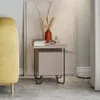 A modern nightstand with a drawer is placed next to a yellow sofa, with a vase of dried flowers and books on top. Produktbild-Vorschau