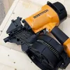 A nail gun rests on a wooden surface. Produktbild-Vorschau