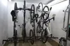 Several bicycles are mounted on a wall rack in a storage area. Náhľad obrázku produktu